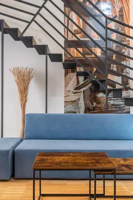 a living room with a blue couch and a wooden table at Le Stanze di Triyah in Palermo
