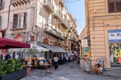 a group of people walking down a street with buildings at Le Stanze di Triyah in Palermo