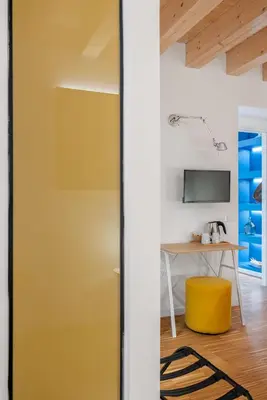 a yellow door in a room with a table and a tv at Le Stanze di Triyah in Palermo