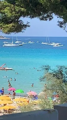 a group of people swimming in the water at a beach at Rocca Mondello Rooms, Beach and Sea in Palermo