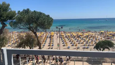 a view of a beach with umbrellas and the ocean at Rocca Mondello Rooms, Beach and Sea in Palermo