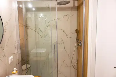 a shower with a glass door in a bathroom at Daria's home apartment rooms in Palermo