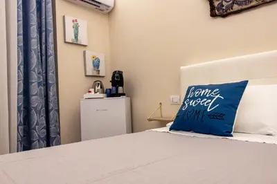 a bedroom with a bed with a blue pillow at Daria's home apartment rooms in Palermo