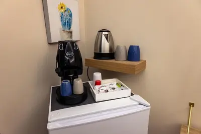 a coffee maker and cups on top of a refrigerator at Daria's home apartment rooms in Palermo