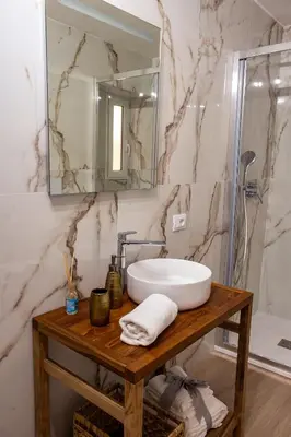 a bathroom with a sink and a mirror at Daria's home apartment rooms in Palermo