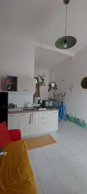 a kitchen with white cabinets and a red couch at Alloggio Garibaldi in Palermo