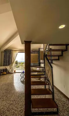 a staircase in a living room with a stair case at Casetta della Muri in Isola delle Femmine