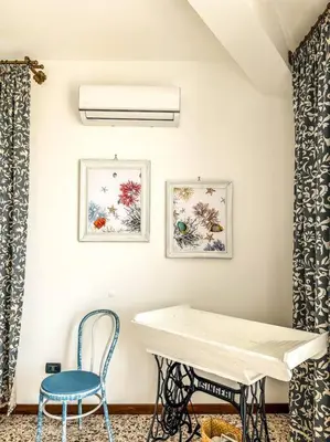 a room with a white table and a blue chair at Casetta della Muri in Isola delle Femmine