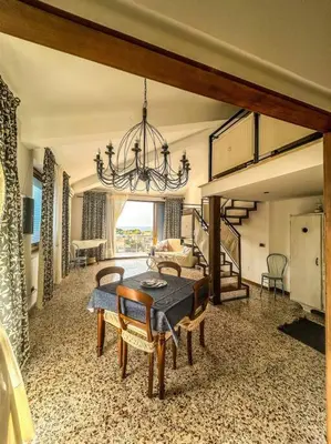 a dining room with a table and a chandelier at Casetta della Muri in Isola delle Femmine