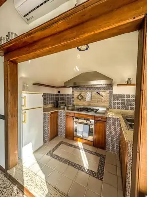 a kitchen with a stove and a refrigerator at Casetta della Muri in Isola delle Femmine