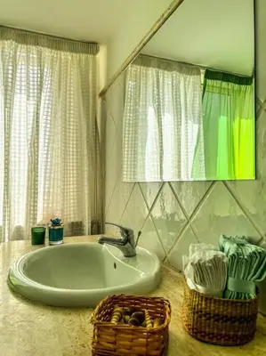 a bathroom with a sink and a mirror and a basket at Casetta della Muri in Isola delle Femmine