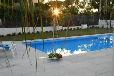 a pool in a backyard with a table and a chair at Villa dei Pioppi Deluxe in Carini