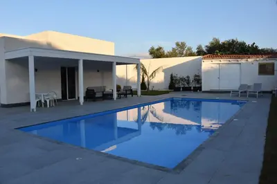 a swimming pool in front of a house at Villa dei Pioppi Deluxe in Carini