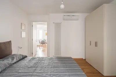 a white bedroom with a bed and a hallway at Little House Mavi by DomuSicily in Palermo