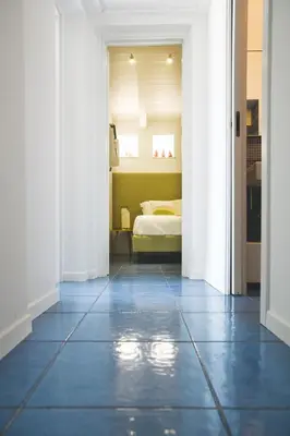 a bedroom with a bed and a blue tile floor at Villa sulla spiaggia Riva Estate by Le Dhome Sicily in Trappeto
