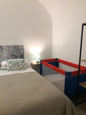 a bedroom with a bed with a red and blue rail at Le Antiche Alcove in Terrasini