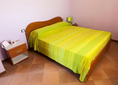 a bedroom with a bed with a yellow blanket on it at Case Vacanza Longo in Balestrate