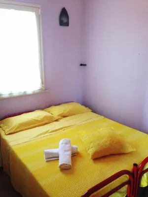 a bedroom with a yellow bed with a towel on it at Case Vacanza Longo in Balestrate