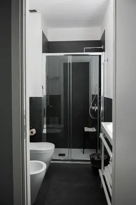 a bathroom with a toilet and a glass shower at Alma Hotel in Palermo