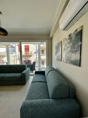 a living room with a couch and a large window at The White Lodge in Porticello