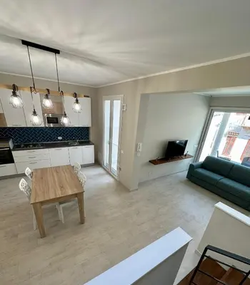 a living room with a table and a green couch at The White Lodge in Porticello