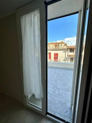 an open window with a view of a building at The White Lodge in Porticello