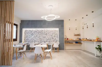 a dining room with white tables and white chairs at Acquamarina Rooms in Castellammare del Golfo