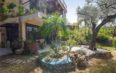 a garden in front of a house with a tree at 3 Bedroom Lovely Home In Borgetto in Borgetto