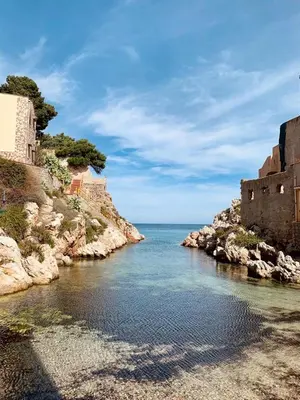a body of water next to a rocky shore at The White Lodge in Porticello