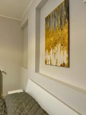 a bedroom with a painting hanging on a wall at The White Lodge in Porticello