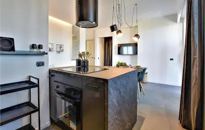 a kitchen with a black island in a room at Beautiful Apartment In Trappeto in Trappeto