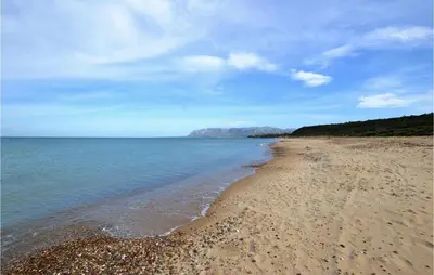 a sandy beach with a mountain in the background at Beautiful Apartment In Trappeto in Trappeto