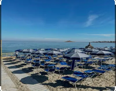 a bunch of chairs and umbrellas on a beach at Sicilia House bluchic in Isola delle Femmine