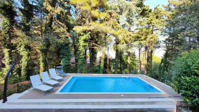 a swimming pool with two chairs and a swimming poolvisor at Villa Calici in Pioppo