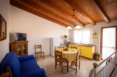 a living room with a table and a kitchen at Sunshine Apartments in Trappeto