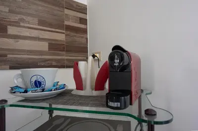 a glass table with a coffee maker and cups on it at CAMA Casa Vacanze - Qui vivi la vera storia normanna in Palermo