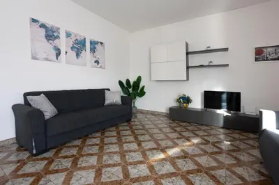 a living room with a couch and a kitchen at CAMA Casa Vacanze - Qui vivi la vera storia normanna in Palermo
