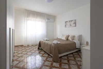 a bedroom with a bed and a window at CAMA Casa Vacanze - Qui vivi la vera storia normanna in Palermo