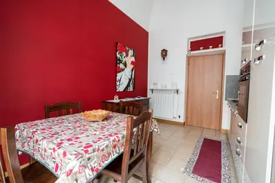 a dining room with a table and a red wall at Plumeria Vacanze in centro a Palermo- Isidoro Carini zona Politeama in Palermo