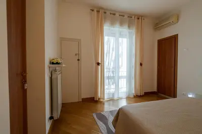 a bedroom with a bed and a large window at Plumeria Vacanze in centro a Palermo- Isidoro Carini zona Politeama in Palermo
