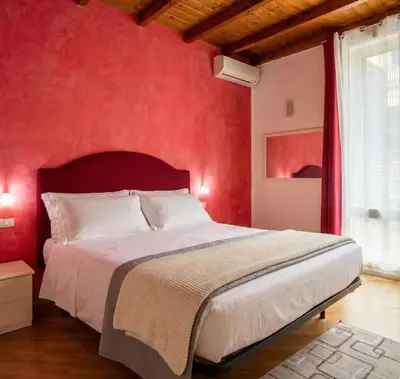 a bedroom with a red wall with a large bed at Plumeria Vacanze in centro a Palermo- Isidoro Carini zona Politeama in Palermo