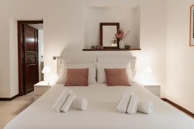 a large white bed with two white towels on it at Four Luxury Art in Palermo