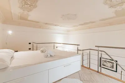 a white bedroom with a large bed with white sheets at Four Luxury Art in Palermo