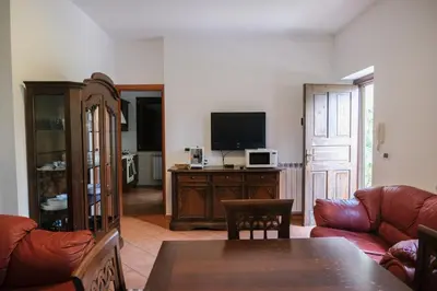 a living room with a couch and a television at Grande Villa con Giardino e BBQ vicino al Mare in Mondello