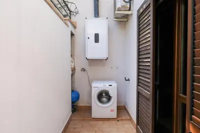 a small bathroom with a washing machine in it at Grande Villa con Giardino e BBQ vicino al Mare in Mondello