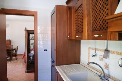 a kitchen with wooden cabinets and a sink at Grande Villa con Giardino e BBQ vicino al Mare in Mondello
