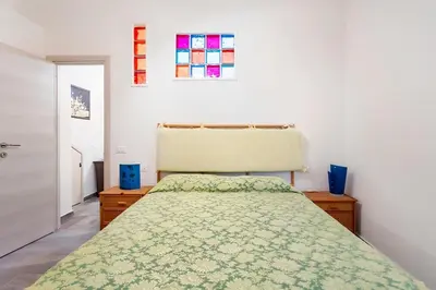 a bedroom with a bed with a green bedspread at Casa Lo Re in Bagheria
