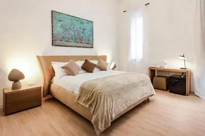 a bedroom with a large bed and a night stand at Kepos Rooms and Suites in Palermo