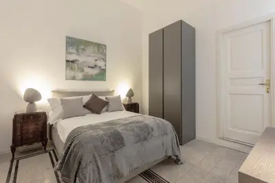 a white bedroom with a bed and a window at Kepos Rooms and Suites in Palermo