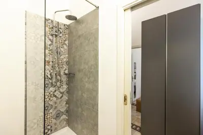 a bathroom with a shower with a glass door at Kepos Rooms and Suites in Palermo